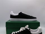 black and white sneakers with white laces on top of a green box