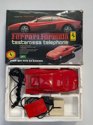 une voiture rouge qui se trouve dans une boîte avec un chargeur