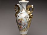 a white vase with a gold decoration on it