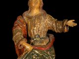 statue of a man sitting on a chair with his arms outstretched