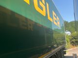a green and yellow truck that is driving down the road