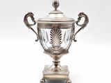 un trophée ancien en métal argenté, muni d'un couvercle en verre