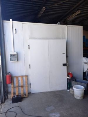 une photo d'un garage avec un réfrigérateur et d'autres objets