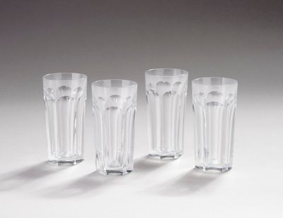 quatre verres transparents sont alignés sur une surface blanche