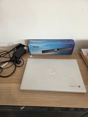 a laptop computer sitting on a desk next to a charger