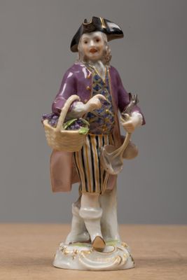 a figurine of a man with a basket on a table