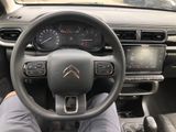 someone is sitting in the driver ' s seat of a car with their feet on the steering wheel