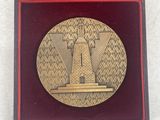 an image of a gold medal in a red box on a white surface
