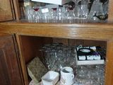 une armoire en bois sur laquelle sont disposés de nombreux objets en verre