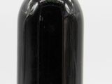 a black bottle with a red cap and a label on it