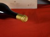 a bottle of wine sitting on a red table cloth