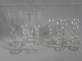 six verres à vin transparents sont alignés sur une surface blanche
