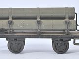 une maquette de wagon de train sur laquelle sont empilés plusieurs fûts