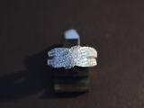 a silver ring with a knot on it on a black surface