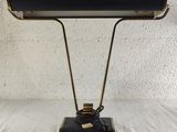 a black and gold desk lamp on a white surface