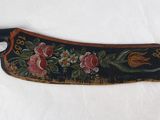 une image représentant un couteau en bois orné d'un motif floral