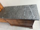un plateau en marbre posé sur une commode en bois dans une pièce