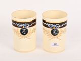 une paire de tasses de couleur crème ornées de motifs noirs et dorés