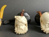 three figurines of animals and a pipe on a table
