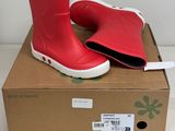 une paire de bottes de pluie rouges posée sur une boîte en carton