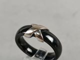 a close up of a black and silver ring on top of a clear glass