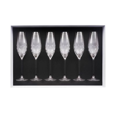 four empty wine glasses in a black box on a white background