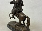 statue of a man riding a horse with a dog on it