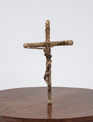 a cross made out of rope on a wooden table