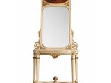 an ornately decorated mirror on a stand with a mirror on top