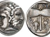 a close up of a silver coin with a face on it