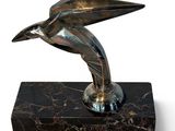 statue of a bird on a marble base on a white background