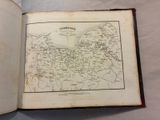 an old book with a map inside of it on a table