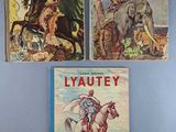 three books are sitting on a blue surface, one of which has a picture of a man riding a horse