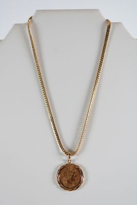 a gold necklace with a wax seal on a white mannequin