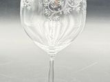 a clear wine glass with a red label on it