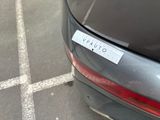 a sticker on the back of a car that is parked in a parking lot