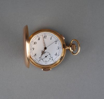 a gold pocket watch on a gray surface