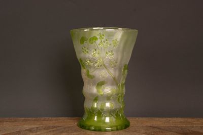un vase en verre vert posé sur une table en bois