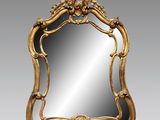 un miroir à cadre doré orné d'un motif décoratif