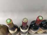 several bottles of wine are lined up in a row on a white surface
