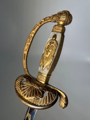an old sword with a gold handle on a table