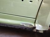 a car that has been painted green and has rust on the side of it