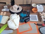 une table sur laquelle se trouvent de nombreux objets, notamment un chapeau, des ciseaux et d'autres objets