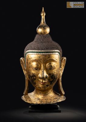 une tête de Bouddha dorée sur fond noir