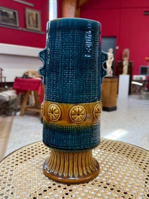 un vase bleu posé sur une table dans une pièce