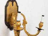 a wall mounted candle holder with two candles on it