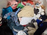 a large pile of clothes in a bin on the floor