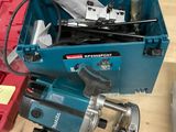 une boîte à outils bleue contenant des outils, posée sur une table en bois
