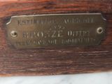 a close up of a brass plate on a wooden table
