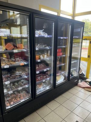 a man sitting on the floor in front of a freezer